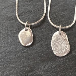 Small sterling silver pendant cast from beach pebbles from Anglesey. Designed and hand made by Carol James of Silverfish Designs