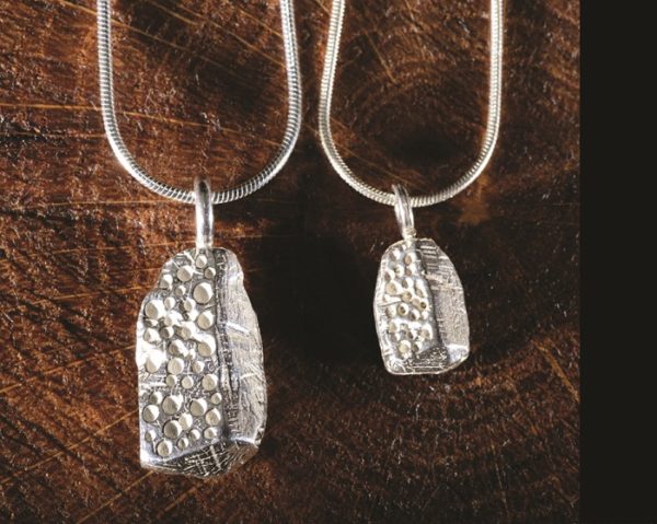 A chunky silver pendant inspired by the carved capstone at Bachwen, North Wales, handmade by Silverfish Designs