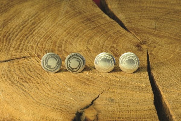 Small silver disc studs inspired by prehistoric carvings at Barclodiad y Gawres, Anglesey, handmade by Carol James of Silverfish Designs