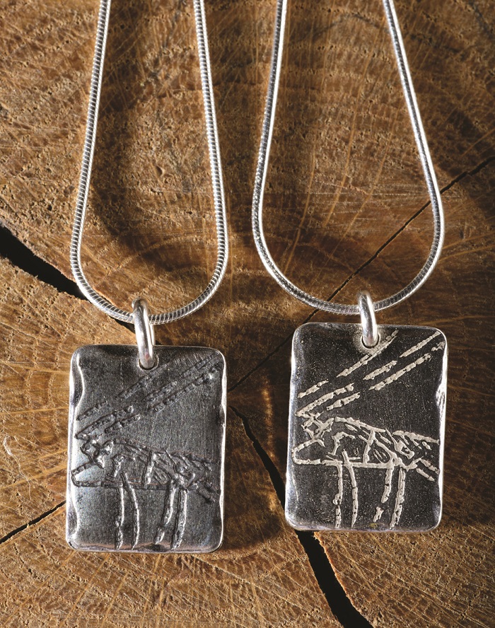A rectangular silver pendant inspired by the deer carved at Cathole Cave, Gower, handmade by Silverfish Designs