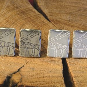 A pair of rectangular cufflinks inspired by prehistoric carvings from Cathole cave on the Gower, designed and created by Carol James of Silverfish Designs