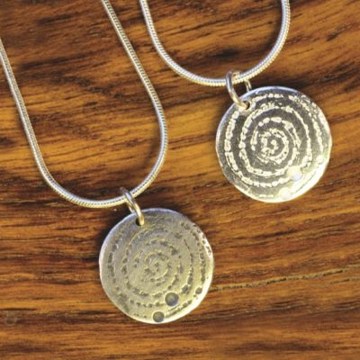 A small silver pendant inspired by the prehistoric carved stone in Llanbedr. Designed and created by Carol James of Silverfish Designs
