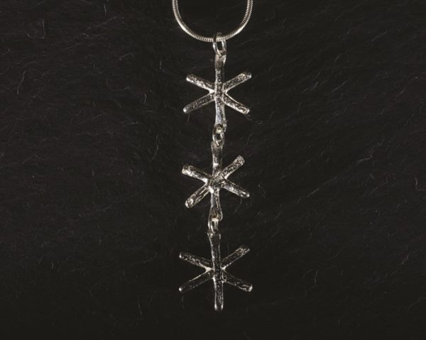 A trio of tiny silver snowflakes hung from a silver snake chain make up this elegant pendant from Silverfish Designs